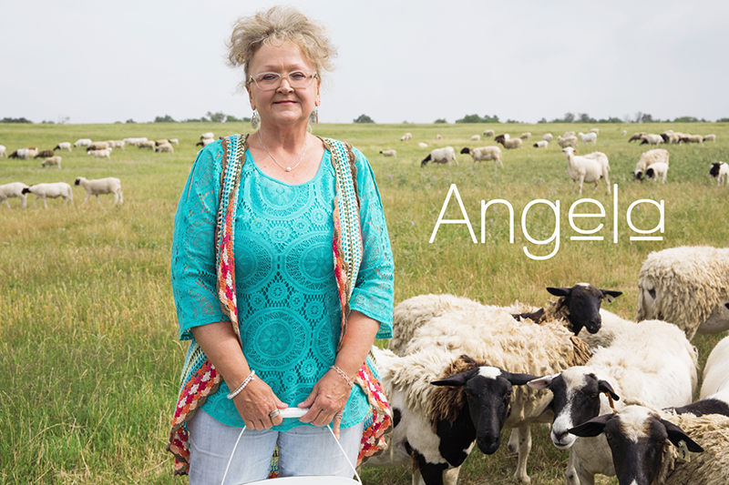 Angela on her farm with livestock in the background.
