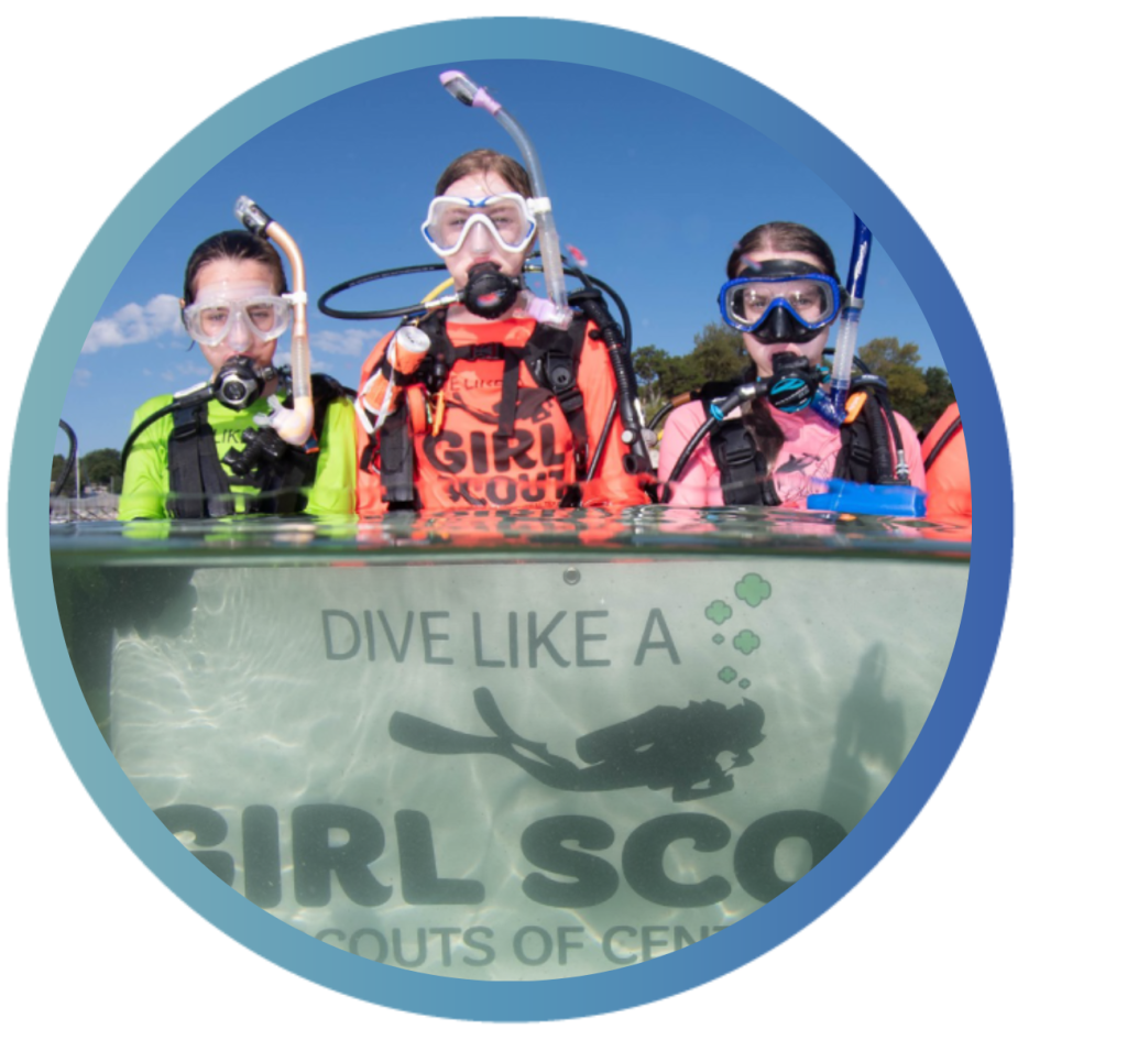 Girl Scouts stand in water with snorkel gear on.